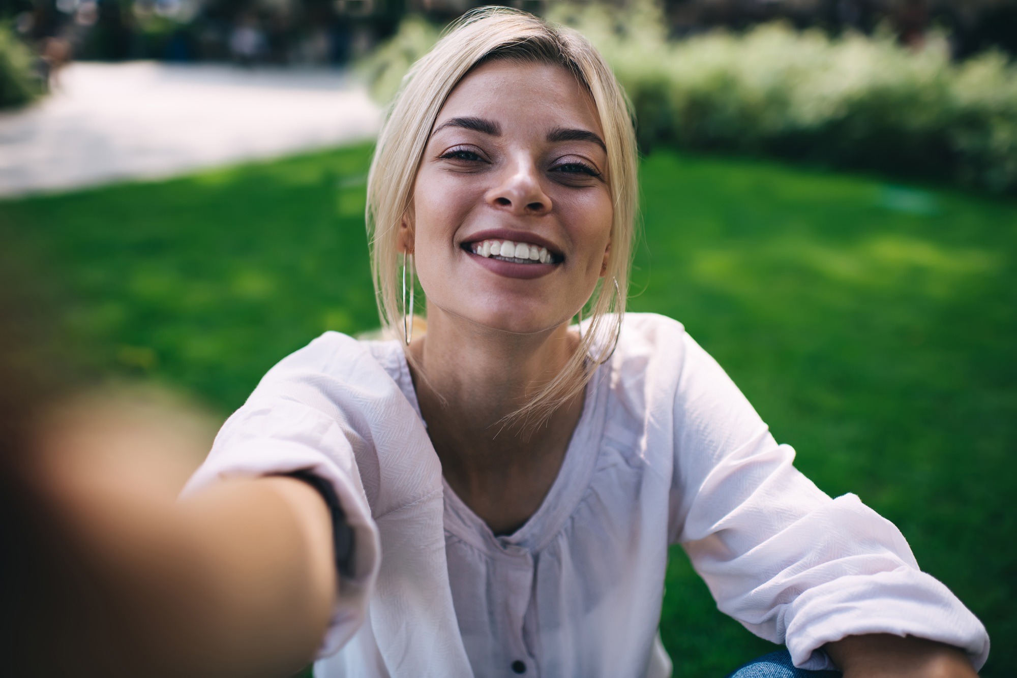 Close up selfie portrait of happy female with perfect toothy smile on face enjoying travel lifestyle